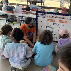 campers on floor around a metamorphosis whiteboard