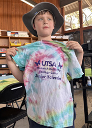 camper holding up tie dye shirt