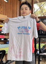 camper holding up tie dye shirt