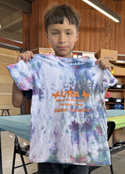 camper holding up tie dye shirt