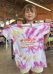 camper holding up tie dye shirt