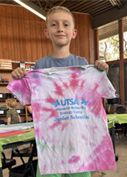 camper holding up tie dye shirt