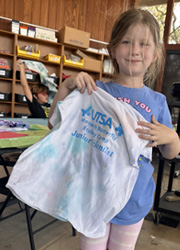 camper holding up tie dye shirt