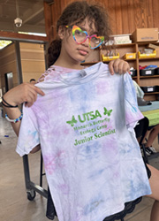 camper holding up tie dye shirt