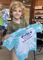 camper holding up tie dye shirt