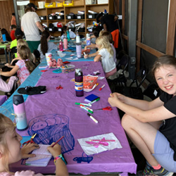 campers doing art at table