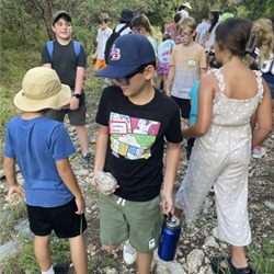 campers looking at rock