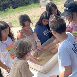 campers working with sand to create rivers