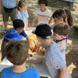 campers working with sand to create rivers