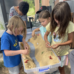 campers working with sand to create rivers