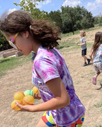 camper running with water balloons