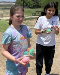 campers holding water balloons