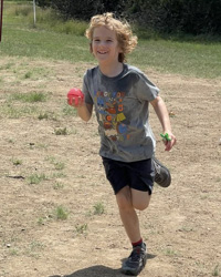 camper running with water balloon