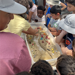 campers working with sand to create rivers