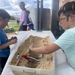 campers working with sand to create rivers