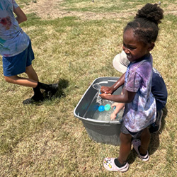 camper holding water balloon