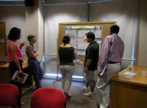 five students looking at a research poster