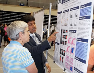 student explaining a research poster to a participant
