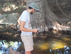 student standing by creek