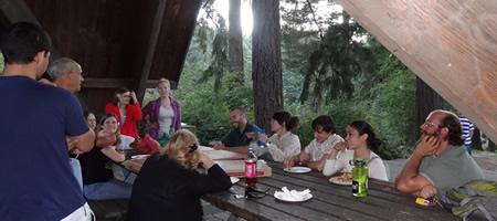 participants eating pizza at picnic table